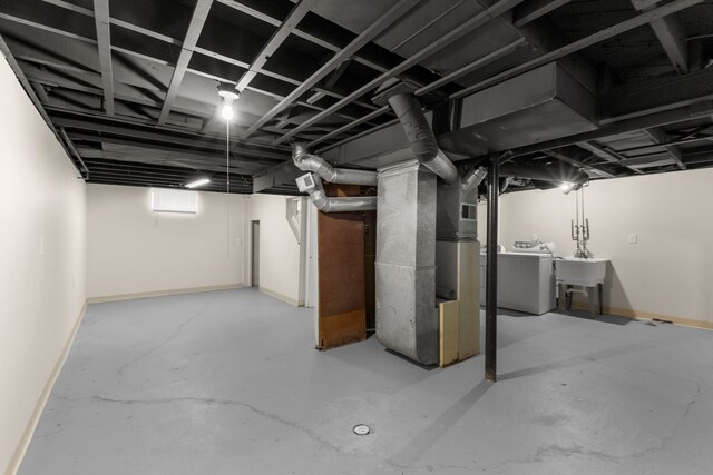 basement with washer / dryer, baseboards, and a sink