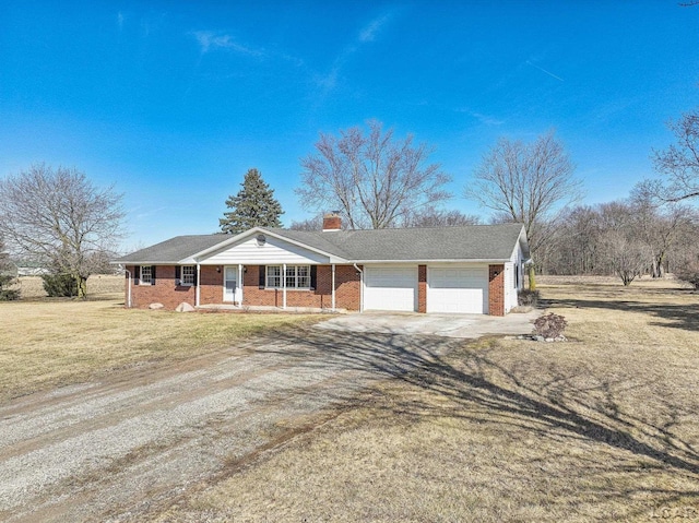 ranch-style house featuring brick siding, an attached garage, a front lawn, a chimney, and driveway