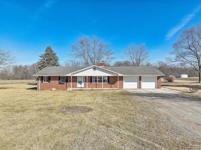 single story home featuring a front yard, brick siding, a chimney, and driveway