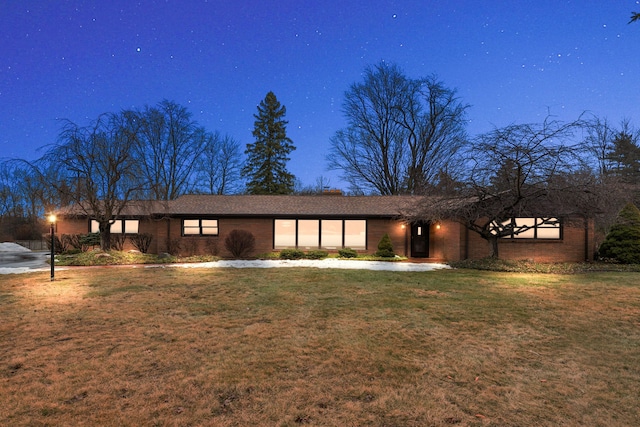 view of front facade with brick siding and a front yard