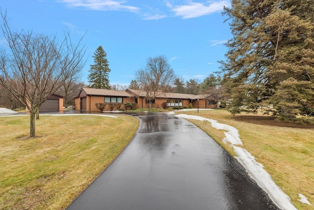 view of front facade featuring driveway, a front lawn, and a garage