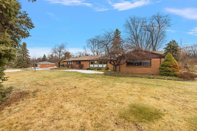 view of front of property featuring brick siding and a front lawn