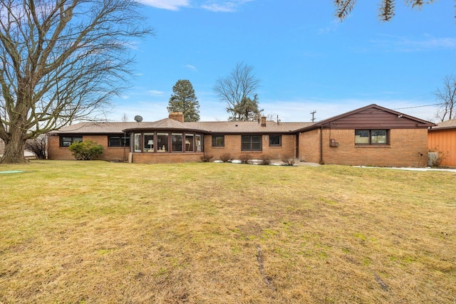 view of front of property featuring a front lawn, brick siding, and a chimney