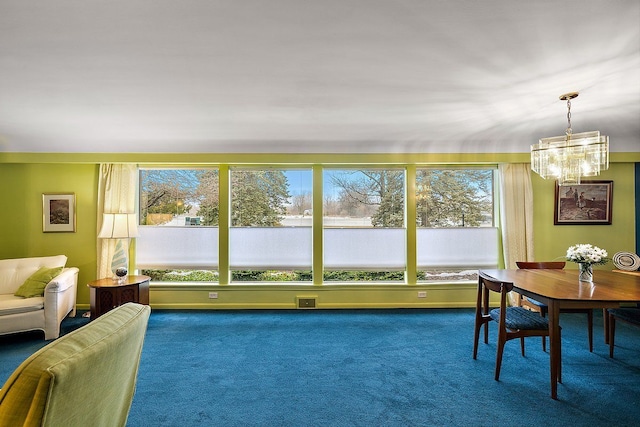 dining space featuring baseboards, carpet floors, plenty of natural light, and an inviting chandelier