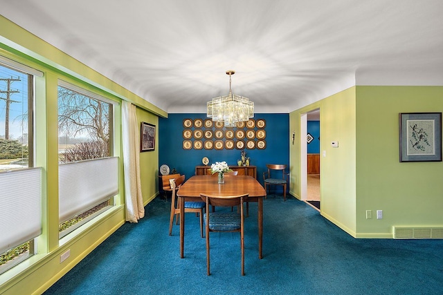 dining space with visible vents, carpet flooring, baseboards, and an inviting chandelier