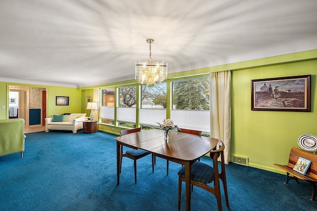 carpeted dining room featuring visible vents, baseboards, and an inviting chandelier