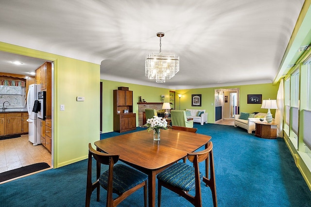 dining room with baseboards, light carpet, and an inviting chandelier