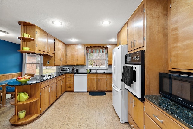 kitchen featuring open shelves, light floors, black appliances, and a sink