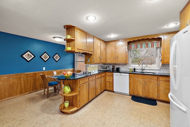 kitchen with a sink, open shelves, white appliances, wainscoting, and light floors