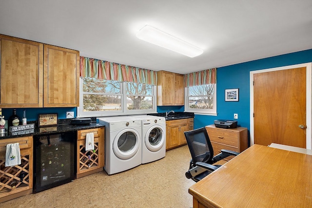 washroom with light floors, cabinet space, separate washer and dryer, a sink, and wine cooler