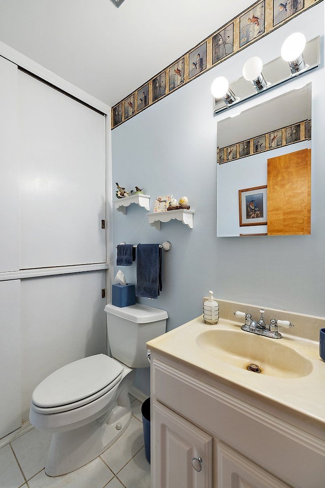 bathroom featuring tile patterned flooring, toilet, and vanity