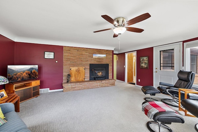 carpeted living area with an accent wall, a ceiling fan, visible vents, and baseboards