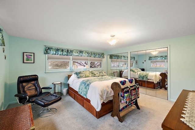 carpeted bedroom featuring baseboards and two closets