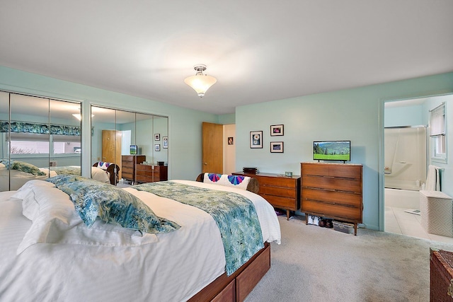 bedroom with ensuite bath and carpet floors