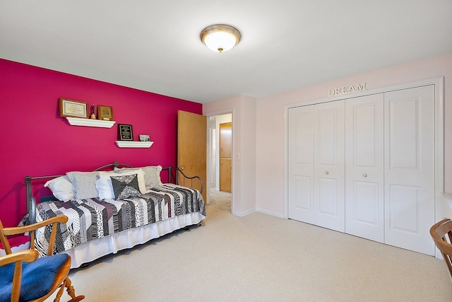 carpeted bedroom featuring a closet and baseboards