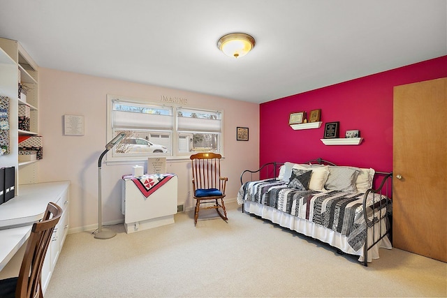 carpeted bedroom with an accent wall and baseboards