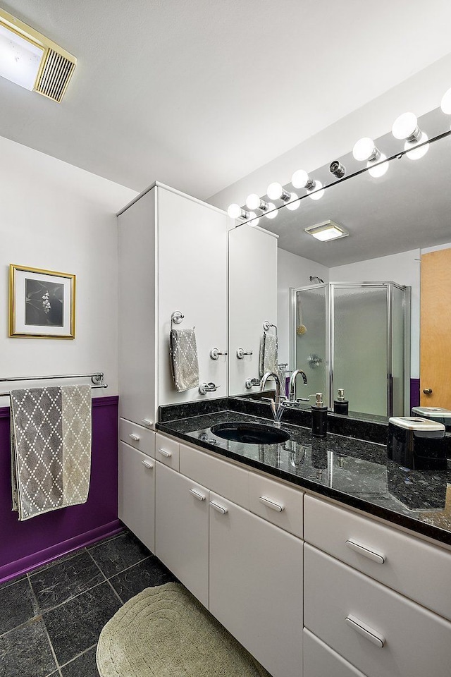 bathroom with visible vents, a stall shower, and vanity