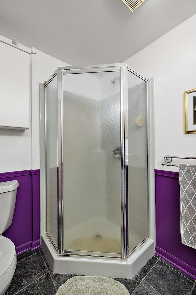 full bath with a stall shower and toilet