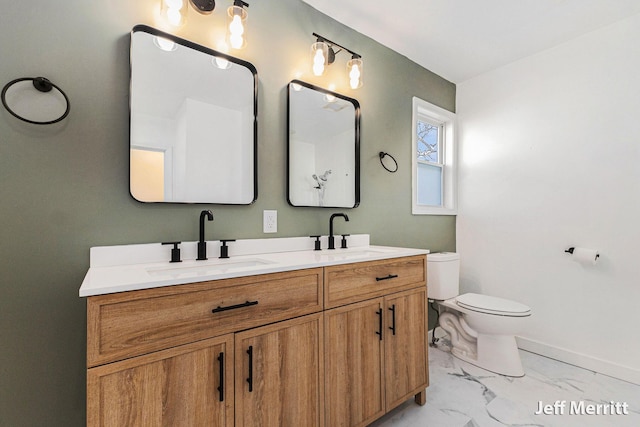 full bath featuring a sink, toilet, marble finish floor, and double vanity