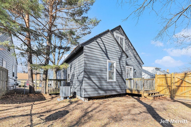 rear view of house featuring a deck, central AC unit, a gate, and a fenced backyard