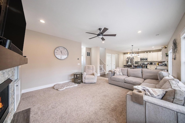 living area featuring stairs, recessed lighting, a fireplace, and carpet floors