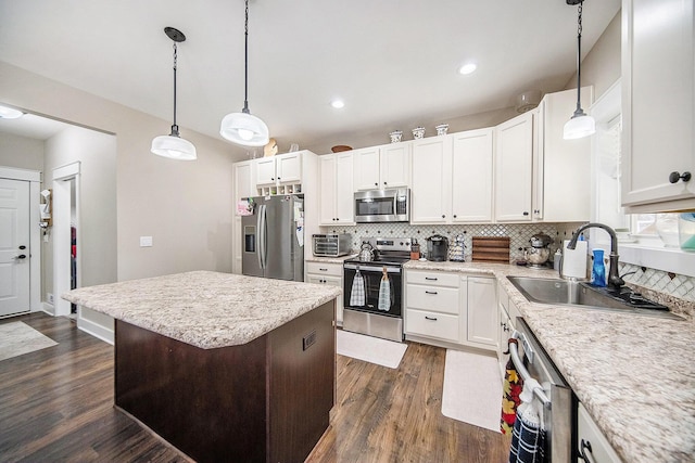 kitchen featuring dark wood finished floors, decorative backsplash, stainless steel appliances, white cabinetry, and a sink