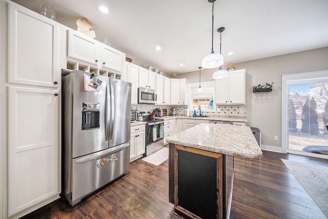 kitchen with backsplash, a healthy amount of sunlight, appliances with stainless steel finishes, and dark wood-style flooring