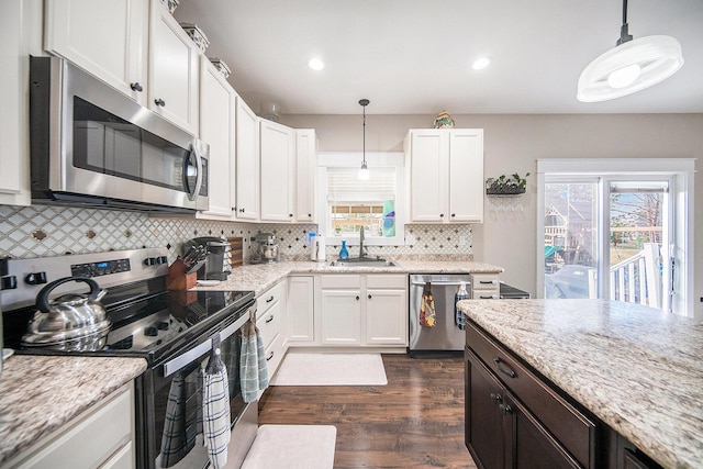 kitchen with white cabinetry, stainless steel appliances, dark wood-type flooring, and a sink