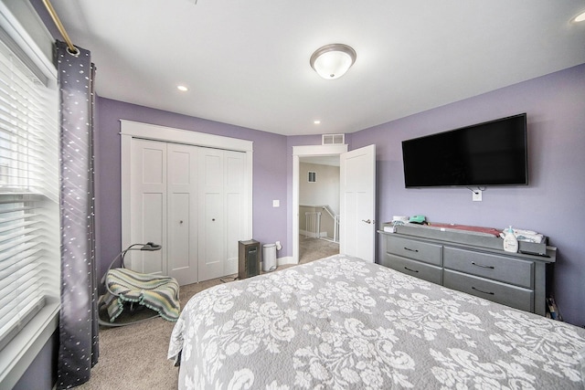 carpeted bedroom featuring visible vents and a closet