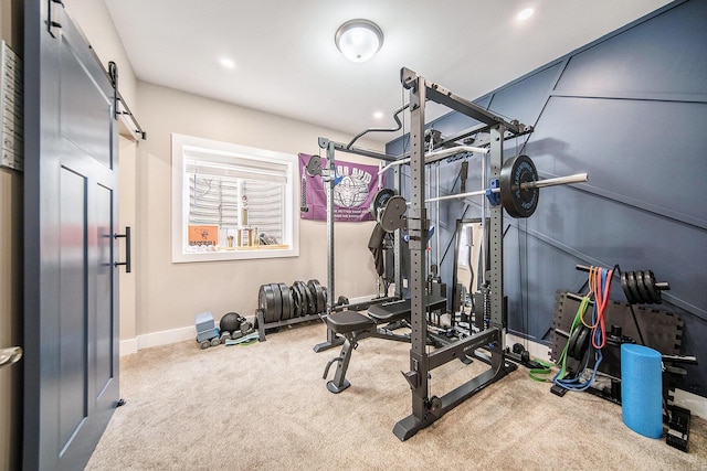 workout area with carpet flooring, recessed lighting, baseboards, and a barn door