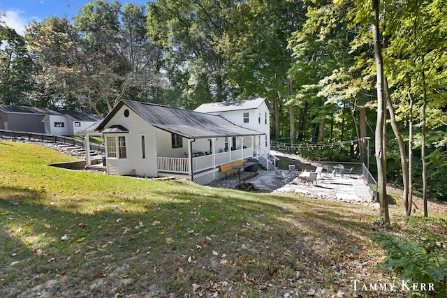 view of side of property featuring a lawn, fence, and a patio