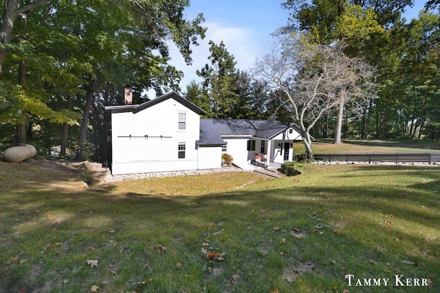 back of house with a yard and a chimney