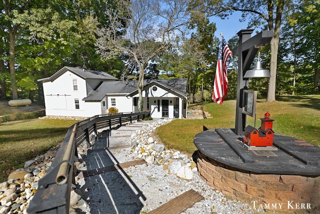 view of front of property with an outdoor structure and a front lawn