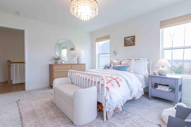 carpeted bedroom with a chandelier and baseboards