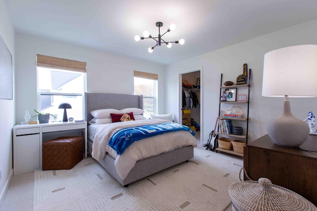 bedroom featuring a walk in closet, an inviting chandelier, a closet, and light carpet