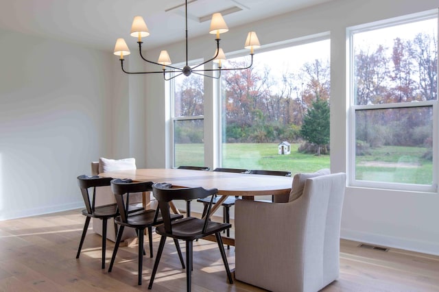 dining space with visible vents, baseboards, an inviting chandelier, and wood finished floors