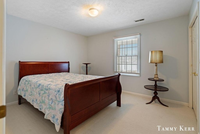 bedroom featuring a textured ceiling, baseboards, visible vents, and light carpet