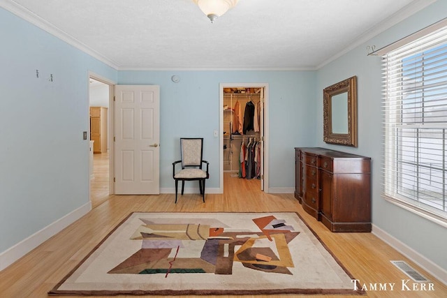 sitting room featuring visible vents, crown molding, baseboards, and wood finished floors