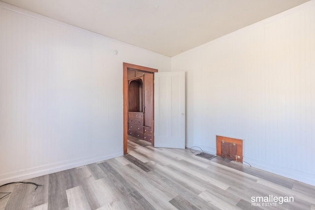 unfurnished room with wood finished floors, baseboards, and ornamental molding