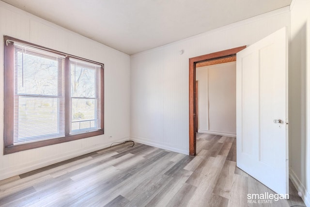 empty room with baseboards and light wood-type flooring