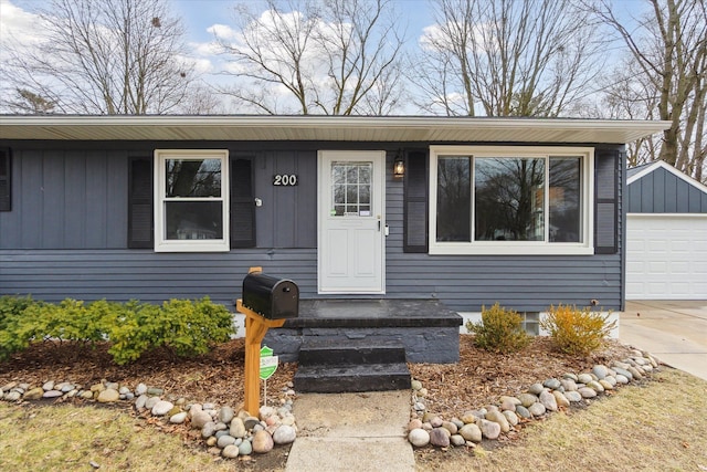 view of front of house with an outbuilding, board and batten siding, and concrete driveway