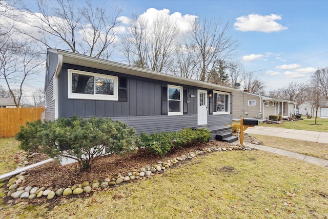 view of front of home featuring a front yard, fence, and board and batten siding