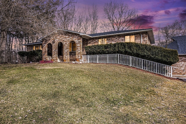 view of front facade featuring brick siding and a front yard