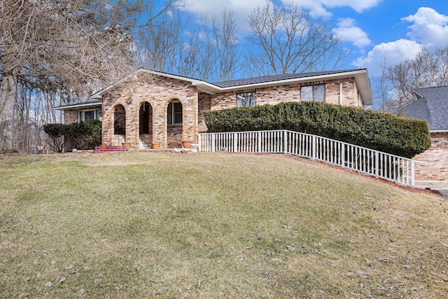 ranch-style home featuring a front yard and brick siding