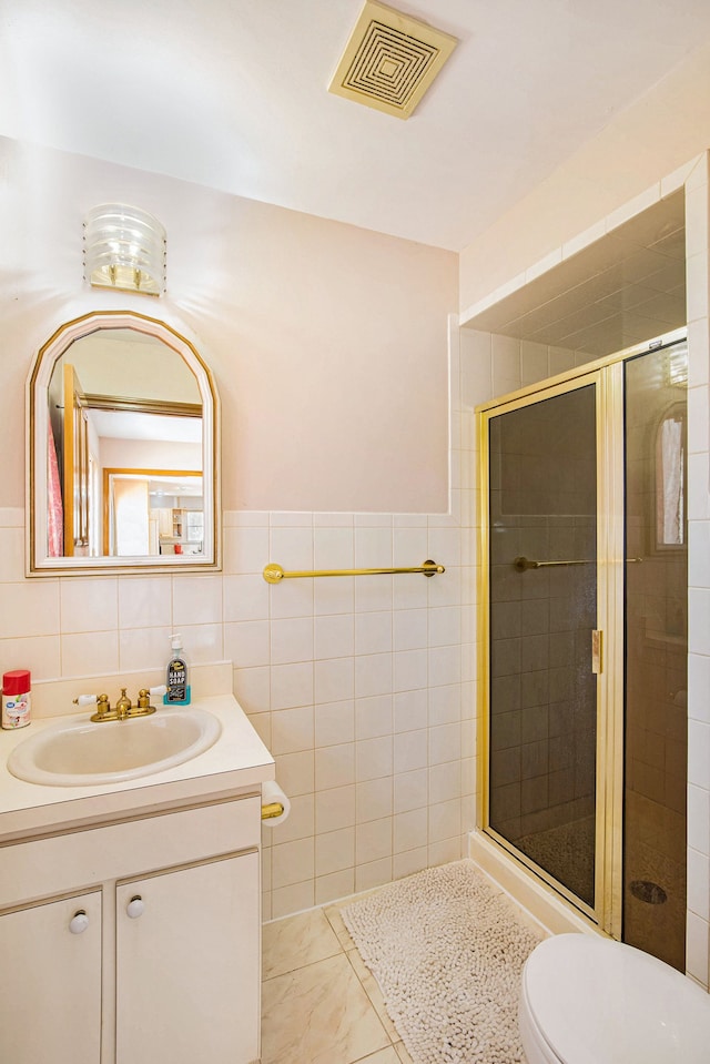 bathroom featuring visible vents, a stall shower, tile walls, and vanity