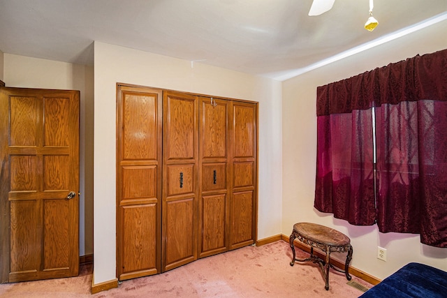 bedroom with visible vents, light colored carpet, baseboards, and ceiling fan