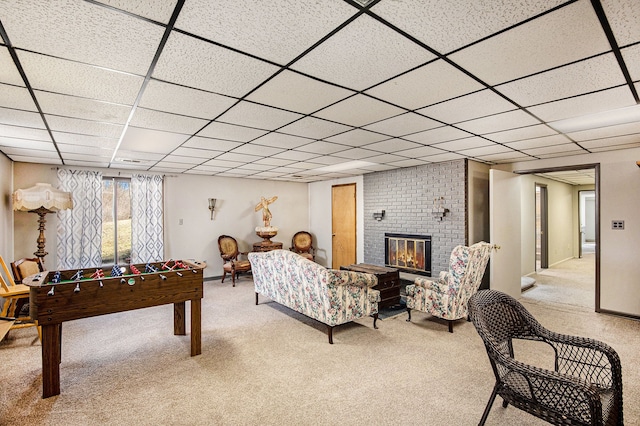 rec room featuring a brick fireplace, carpet, and a drop ceiling