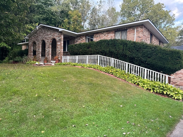 view of front of house with brick siding and a front lawn