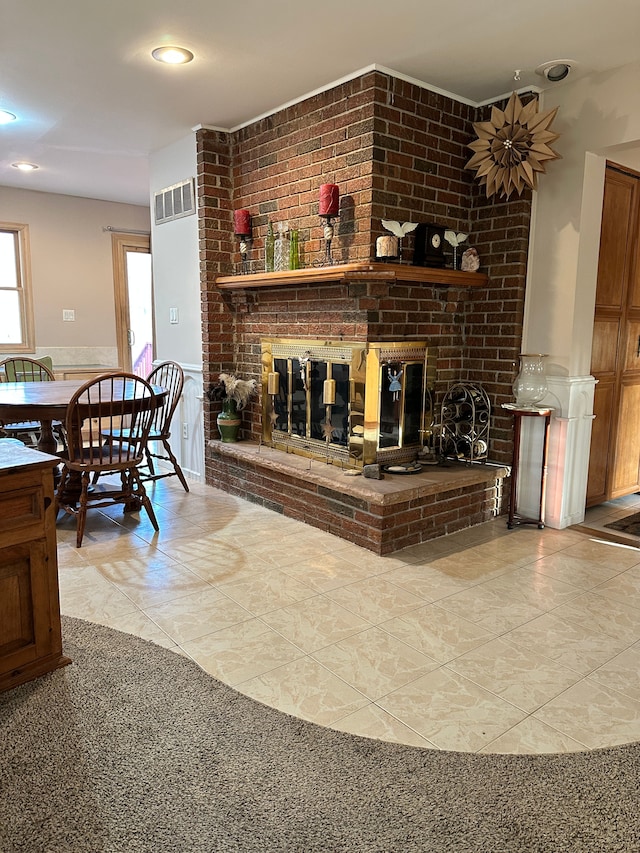 living area with visible vents, a wainscoted wall, and a fireplace