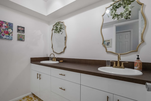 full bath featuring a sink, baseboards, and double vanity